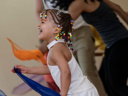 Une petite fille danse avec un foulard dans la salle de danse du CCGV.