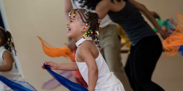 Une petite fille danse avec un foulard dans la salle de danse du CCGV.